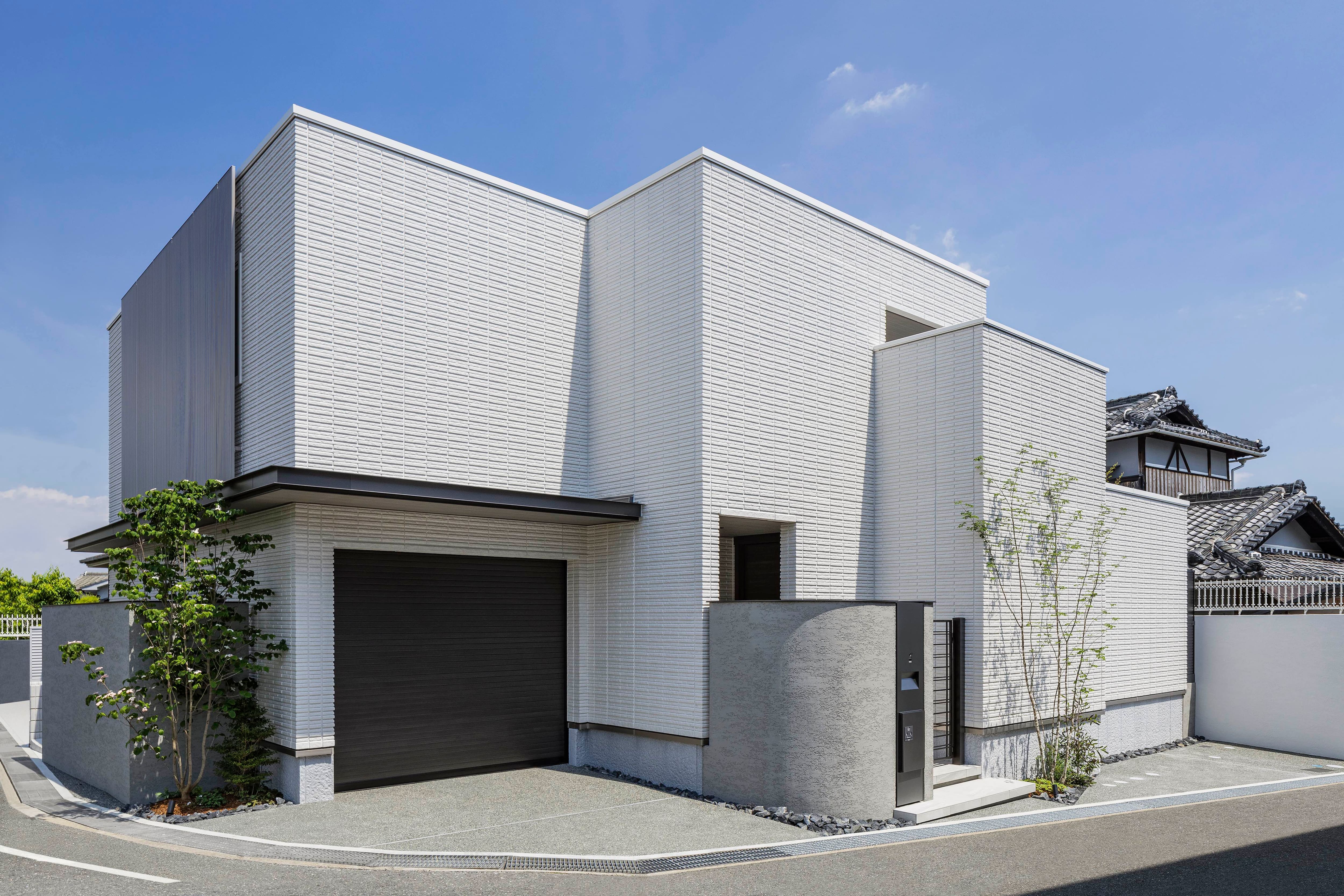 室内の開放感とは対照的なプライバシーに配慮した外観。街並みに調和するよう、ホワイトの外壁で軽やかに仕上げている